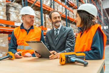 Manager showing inventory results to warehouse workers