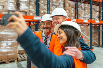 Warehouse workers taking selfie celebrating successful logistics operation