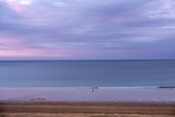 View of the sandy beach at low tide and sunset of Saint-Cast-Le-Guildo in summer in Côtes d'Armor, Brittany, France