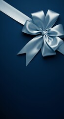 Elegant blue satin ribbon bow on dark blue background for gift decoration