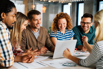 Group of young multi-ethnic startup business team collaborating on project in modern office