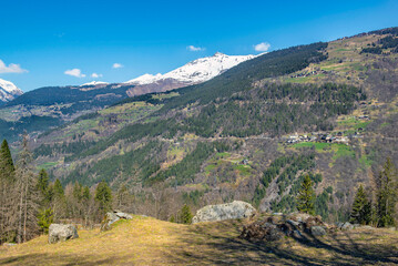 Naklejka premium Mountainous landscape with snow-capped peaks bacground in alpine valley under blue sky