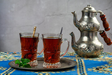 still life with traditional turkish tea in drinking glasses and silver traditional silver tea pot