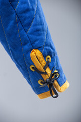 Blue Quilted Sleeve with Yellow Trim and Black Lacing. This image shows a close-up of a blue quilted sleeve with yellow edging and black laces threaded through yellow loops.