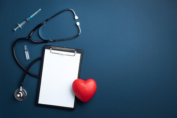 Red heart with doctor stethoscope and notebook on blue background, hospital life insurance concept,...