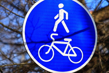 A person rides a bike near a blue sign, suitable for travel or adventure themes.