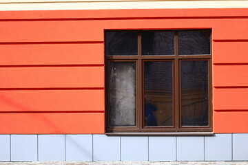 Window at home with a red wall in the city.
