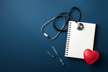 Red heart with doctor stethoscope and notebook on blue background, hospital life insurance concept,...
