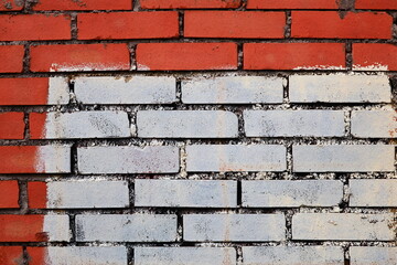 A red and white brick wall with a white line painted on it.