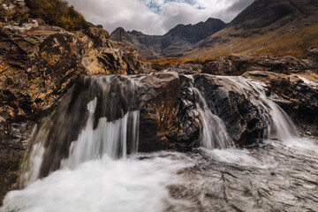 Obraz premium The Isle of Skye’s autumn landscapes blend golden moors, misty peaks, and rugged coastlines. A land of dramatic beauty, where nature’s wild spirit thrives.