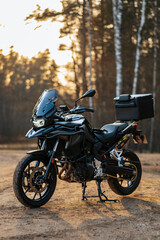 Black adventure motorcycle captured outdoors during sunset
