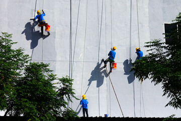 Painters Hanging from a Rope, Painting the Building Exterior Wall.