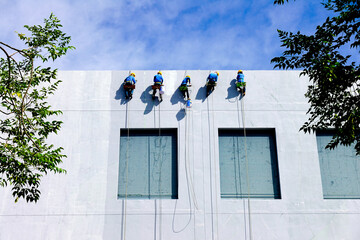 Painters Hanging from a Rope, Painting the Building Exterior Wall.