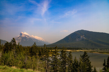Obraz premium Mount Rundle and surrounding pine forest at sunrise reflecting on the Vermilion Lakes, Banff National Park, Canada