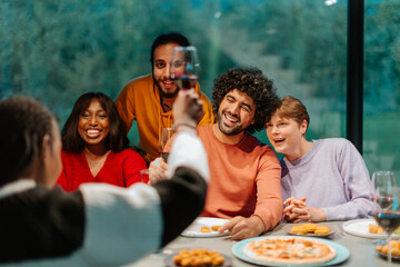 Friends raising glasses for toasting at diverse dinner party