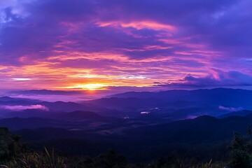 Obraz premium Scenic purple sunrise over majestic mountain range landscape with fog and bright sunlight