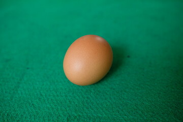 Photo of a chicken egg with a green background