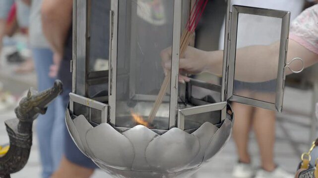 Close-up shot of incense sticks being lit at Wat Chalong in Phuket
