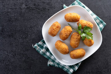 Fried cod croquettes on black slate background. Top view. Copy space