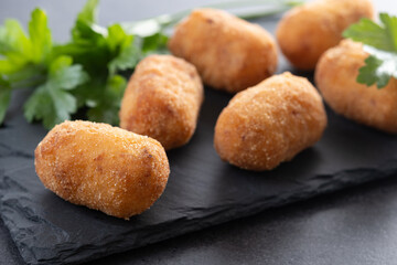Fried cod croquettes on black slate background