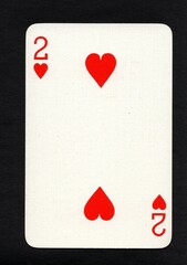 A vintage two of hearts playing card on a black background.