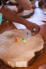 University students examining annual growth rings, putting pushpins in the slice of the tree