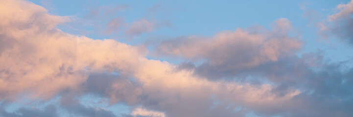 Beautiful sunset sky background with clouds. Scenic cloudscape. Wide panoramic background for design.