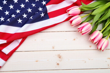 Obraz premium bouquet of pink tulips next to an American flag on a wooden table