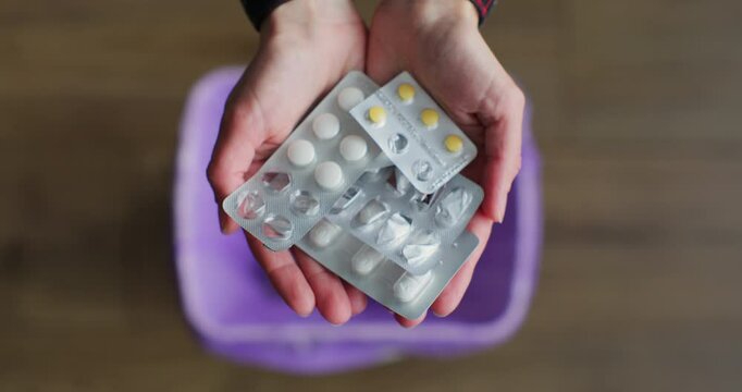 Close up woman hand throws medicine pills into the trash. The concept of the healthcare industry.