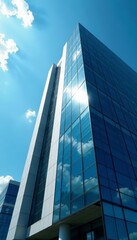 Obraz premium A modern tall office building with reflective windows under bright blue sky, cityscape, urban, skyscraper
