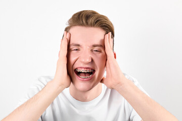 A young man with a concerned expression holding his hands to his ears, possibly indicating loud...