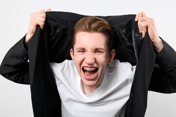 A young man with a fair complexion is captured mid-shout, exhibiting an expression of extreme...
