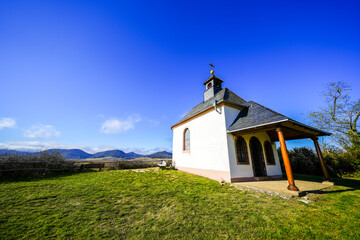Fototapeta premium Landscape with the small chapel of Kleine Kalmit near Landau in the Palatinate. A nature reserve on the hill with a chapel dedicated to the Virgin Mary. 