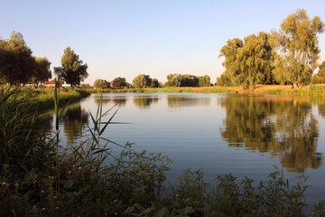 Tranquil countryside riverbank at sunset