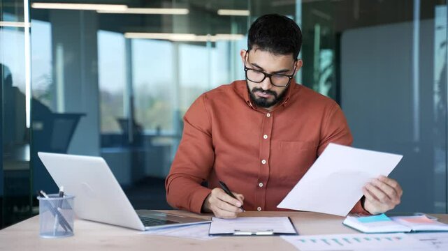 Busy financiers doing paperwork computer while sitting at desk at workplace in business office. Confident businessman working fills out documents, writing, making a tax return or engaged in accounting