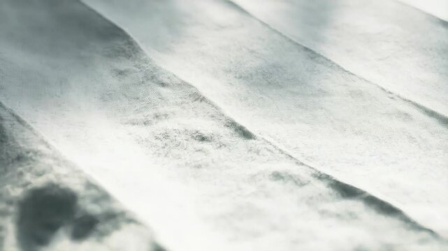 Gentle folds and undulating surfaces come alive under soft light, showcasing a delicate interplay of shadows and textures. This serene moment evokes calm and tranquility
