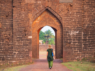 Tourist exploring amazing fort at Bidar, ancient stone wall gateway famous unesco travel destination, Karnataka, India