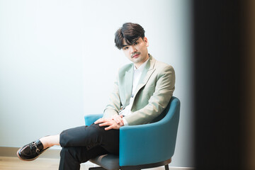 Young Asian businessman in suit sitting on chair isolated on white background,Portrait of a...