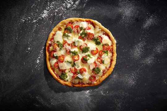Pizza Napoli mit Mozzarella, Kirschtomaten und Pesto &ndash; italienischer Klassiker