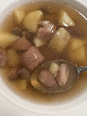 Enjoying a bowl of delicious meat and potato soup, perfect for comforting meals on chilly days