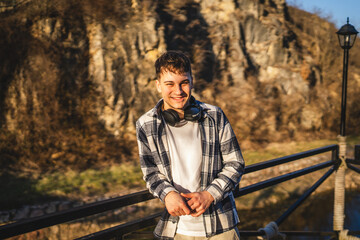 portrait of young man stand and smile in front rock outdoor