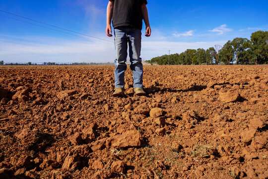 Young boy standing in a freshly harrowed field