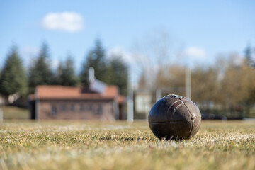 american football ball, worn american football ball and football field, grass and white lines, leather ball