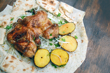 Fried chicken with potatoes. Grilled chicken with potatoes and herbs on a white plate. Roast chicken with potato and onion on pita bread. Restaurant food