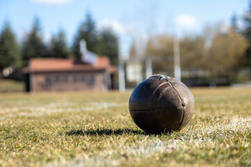 american football ball, worn american football ball and football field, grass and white lines, leather ball