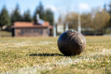 american football ball, worn american football ball and football field, grass and white lines, leather ball