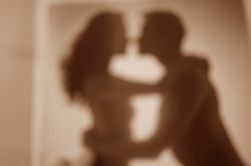 Blurred background. Silhouettes of a man and a woman in love. Making love.