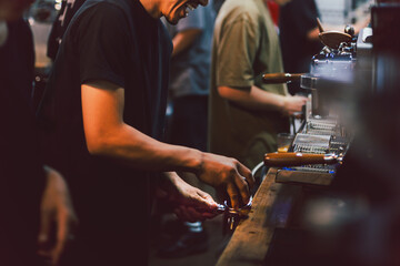 Narrow shot in low light of barista making a fresh coffee in cafe.