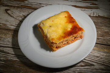 Deliciously baked layers of meat and cheese create a perfect comfort food experience at a cozy dinner setting