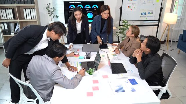 Professional business team collaborating on financial data analysis, sharing insights and strategizing project details within modern corporate workspace